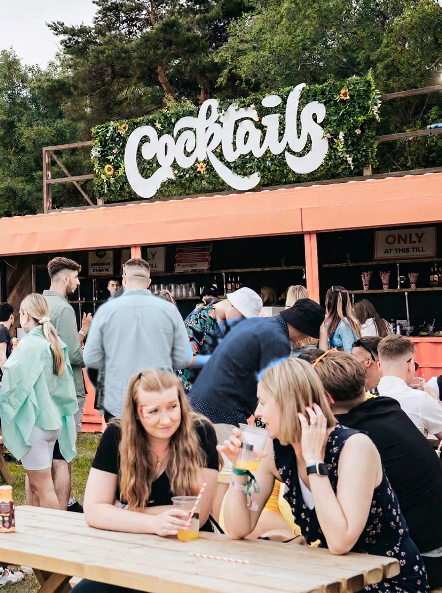 A busy festival cocktail bar built from an orange shipping container, with customers queueing at the counter and drinking at picnic tables